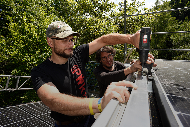 Fachkräfte installieren eine Photovoltaikanlage auf einem Dach – für nachhaltige Energie und Kosteneinsparungen.